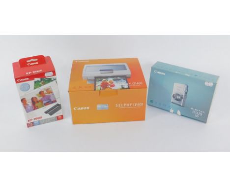 A Canon Digital IXUS 50 camera, Canon Selphy CP400 compact photo printer, and Canon colour print paper, KP-1081P, all boxed. 