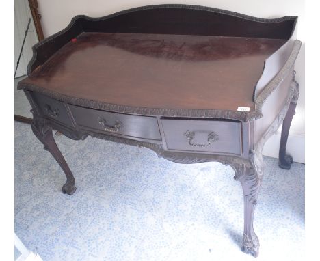 A Chippendale style mahogany dressing table, with a three quarter gallery back, three frieze drawers, and leaf carved cabriol