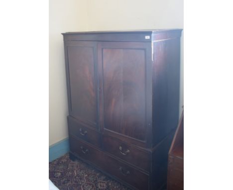 A 19th century mahogany linen press, of small proportions, having a pair of panel doors enclosing sliding trays, the base wit