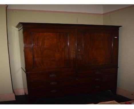 A 19th century mahogany linen press, having a pair of panel doors above two short and two graduated long drawers, on splay br