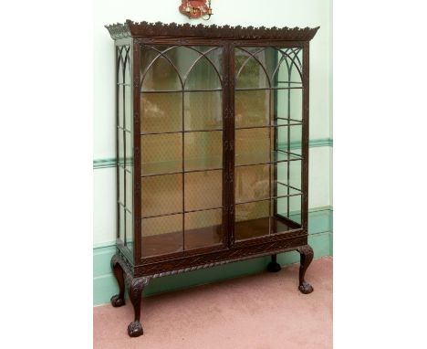 An 18th century style Chippendale display cabinet, the cornice carved leaves, having a pair of bar glazed doors, the frame wi