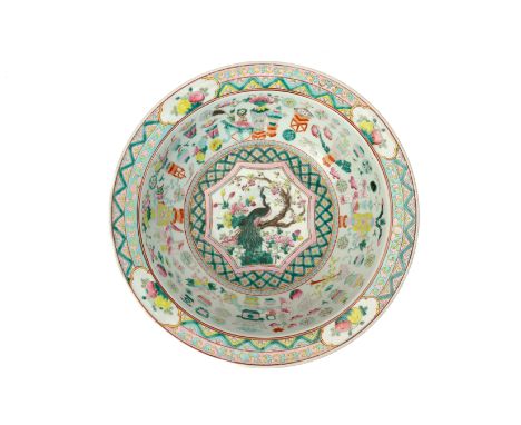 A LARGE FAMILLE ROSE PORCELAIN BASIN The centre with a peacock perched on a blossoming tree, within a pink and green diaperwo
