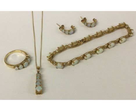 A good opal mounted bracelet together with matching gold pendant, earrings and ring. Approx. 14.2 grams. Est. £100 - £150.