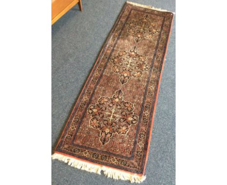 A good quality runner in red ground decorated in bright colours. Approx. 74 cms x 110 cms. Est. £40 - £60.