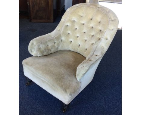 A large button back armchair on turned supports. Est. £30 - £50.