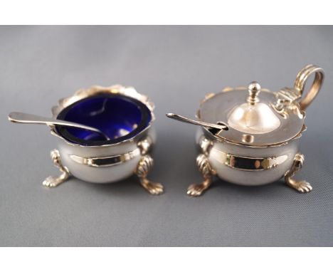 A silver cruet set of plain early Georgian rounded form, comprising an open salt, lidded mustard, caster and two spoons, Lond