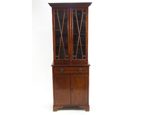 An Edwardian mahogany display cabinet with two glazed doors above one drawer and two panelled doors on bracket feet