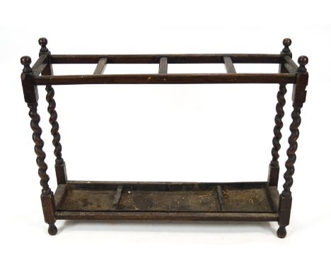 An oak stick stand, the top with four sections on barley twist supports, 70.5cm high x 91cm wide x 25cm deep
