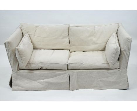 A yellow upholstered two seat Knole style sofa, loose covered in natural coloured linen and set six back and seat cushions, 7
