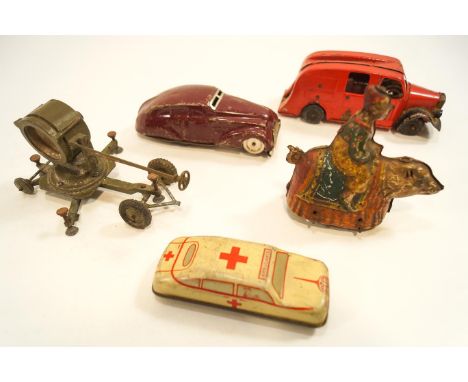 Two tin plate cars, together with a tin plate clown on a bear, another car and a military search light