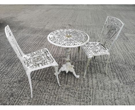A cast metal round form garden table with pierced geometric patterning on a decorative baluster stem with tripod base, togeth