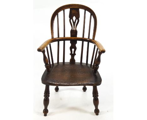 A child's antique Windsor chair with bentwood rail and arms, stick back set with a central pierced splat on an elm seat and t