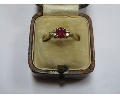 18ct GOLD DRESS RING SET WITH CENTRAL RUBY COLOURED STONE PLUS SIX SMALL CLEAR STONES 