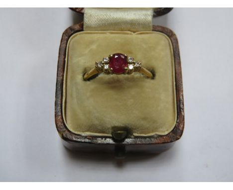 18ct GOLD DRESS RING SET WITH CENTRAL RUBY COLOURED STONE PLUS SIX SMALL CLEAR STONES 