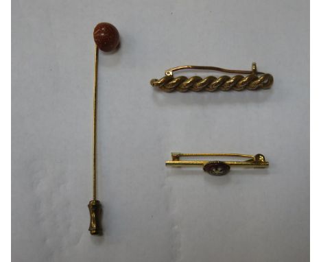 TWO UNHALLMARKED YELLOW METAL BROOCHES AND STICK PIN