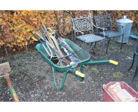A metal garden wheel barrow and contents of various tools