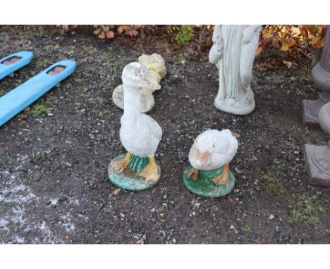 A near pair of concrete garden ornaments in the form of geese 