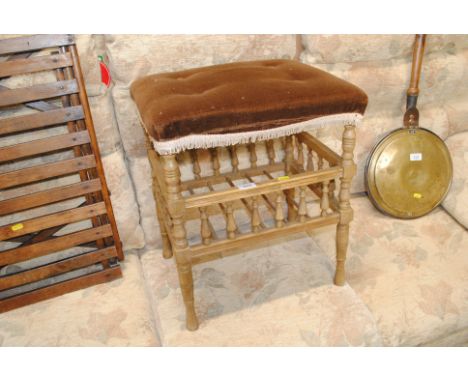 A button down upholstered stool raised on turned wooden supports