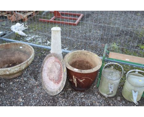 A galvanised planter and a concrete bird bath