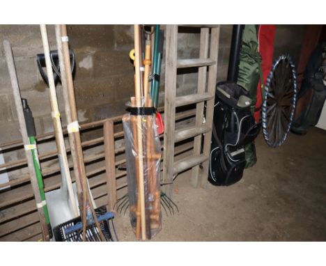 A bag containing various curtain poles and a bundle of long handled gardening tools 