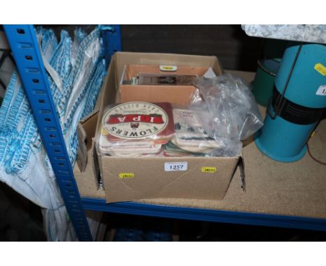 A box containing various vintage postcards and beer mats