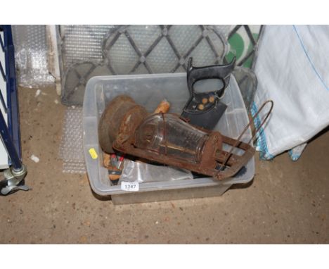 A plastic crate containing a Hurricane lamp and various handtools