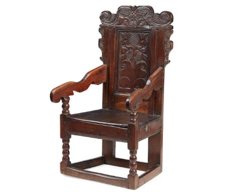  SCOTTISH OAK WAINSCOT ARMCHAIR 17TH CENTURY the scroll carved crest rail with stylised plant forms and leaves above a panel 
