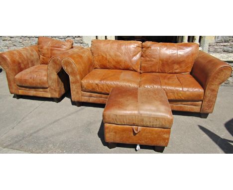 A good quality leather sofa, matching chair and footstool, all upholstered in a mid tan coloured leather, the sofa two metres