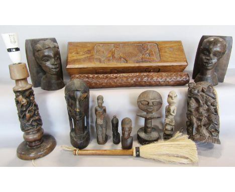 A collection of African carved wood items including a pair of bookends, a table lamp, carved wood figures, a fly swat, rain s