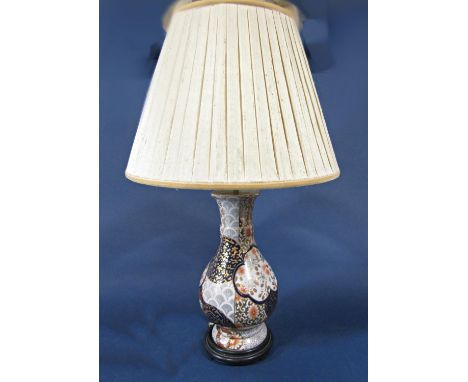 An oriental lamp base of high waisted form with all over blue, burnt orange and gilt floral decoration, 41cm tall (excluding 