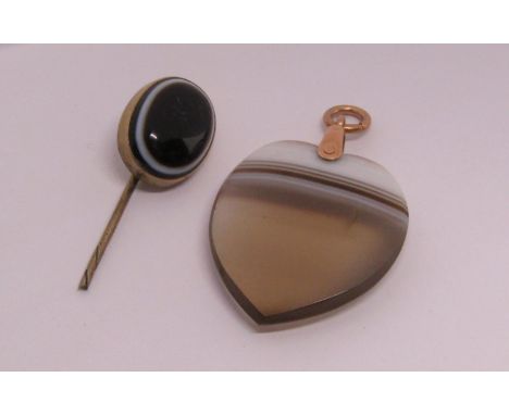 Carved banded agate heart shaped pendant with yellow metal loop, together with a further cabochon banded agate stick pin term