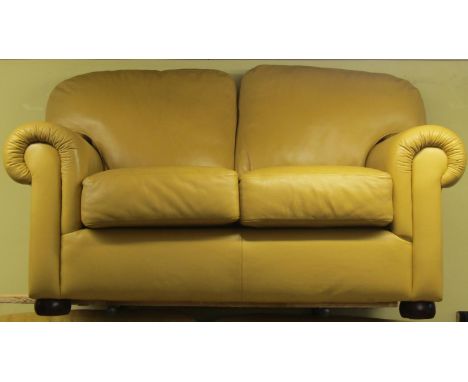 A Saxon two seater sofa in mustard coloured leather fabric, with scrolled arms raised on bun feet, 170cm wide