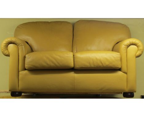 A Saxon two seater sofa in mustard coloured leather fabric, with scrolled arms raised on bun feet, 170cm wide