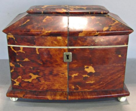 A Regency tortoiseshell tea caddy with two compartments, complete with covers, with a stepped lid raised on ball feet. 19cm w