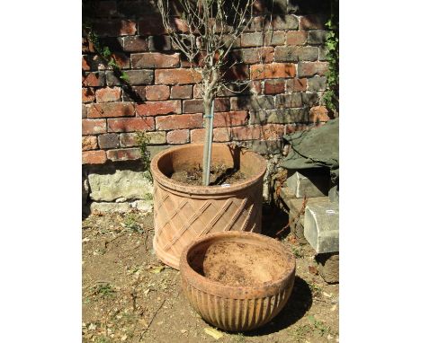 A weathered contemporary terracotta squat cylindrical lattice planter (planted), 48 cm diameter x 39 cm high together with on