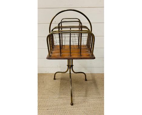 A brass magazine rack on tripod feet 