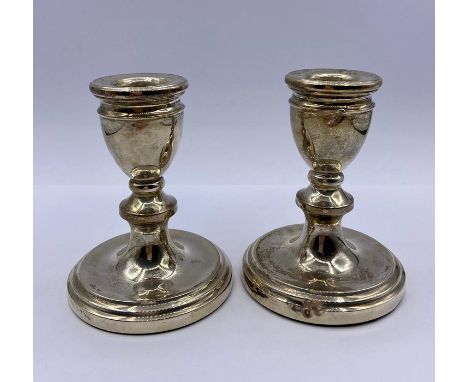 A Pair of silver squat candlesticks by A T Cannon Limited and hallmarked Birmingham 1977.