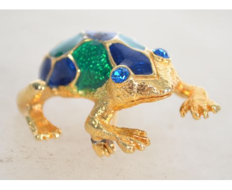 A signed gold tone enamel figural brooch in the form of a frog with roller clip clasp. Measures 3.5cms.