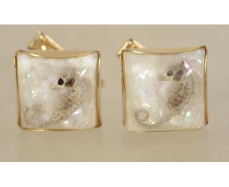 A vintage pair of 1970s cufflinks in gold tone metal with seahorses and iridescent glitter set in lucite. Measures 1.5cms.