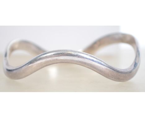 A sterling silver 925 bangle bracelet of wave form. Measures 7 cm wide and weighs 34.2 grams.