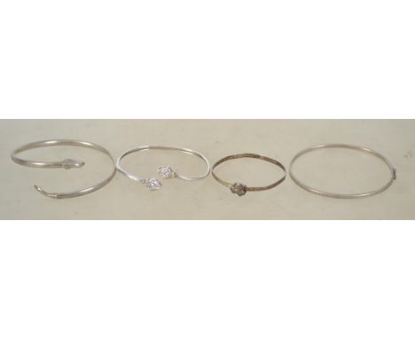 A group of 4 sterling silver 925 bangle bracelets, one having heart shaped rhinestone ends, one having plane shaped ends, one