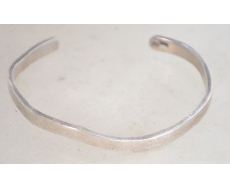 A hallmarked silver 925 bangle bracelet of wave form. Weighs 14.1 grams and measures 6 cm wide.