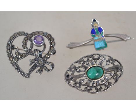 A group of three silver brooches one being a marcasite heart bow brooch having pink amethyst stone, one being of pierced form