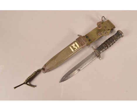 A US M3 Combat/Fighting knife by Camillus, having makers name to the cross guard, leather washer grip, complete with M8A1 sca