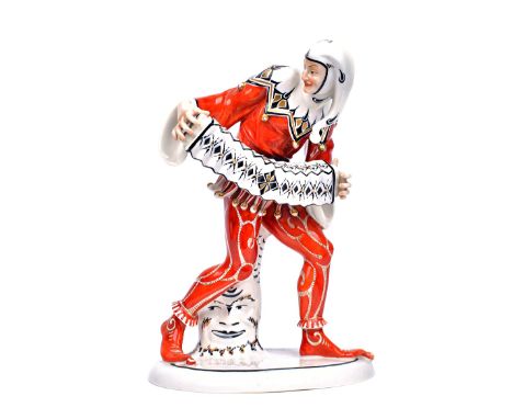 A Schwartzberger Werk porcelain figure of a jester, circa 1920, modelled standing dressed in an elaborate iron red costume, h