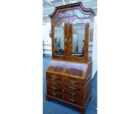 An 18th century German figured walnut bureau cabinet, the pair of mirrored doors over a fitted interior, one long, two short 