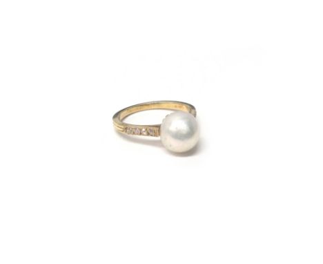 A gold, freshwater cultured pearl and diamond ring, mounted with a freshwater cultured pearl at the centre, between diamond s