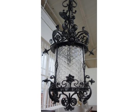 A Victorian style black painted wrought iron lantern, late 20th century, with a long suspension rod over a circular frame and