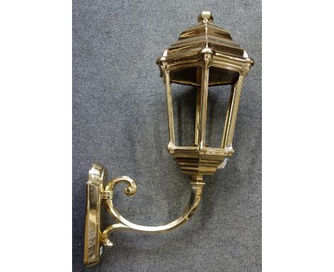 A Victorian style gilt brass wall lantern of large proportions, modern, the hexagonal tapering light supported by a scroll ar