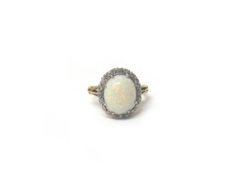 A gold, opal and diamond ring, claw set with the oval opal at the centre, within a surround of circular cut diamonds, detaile